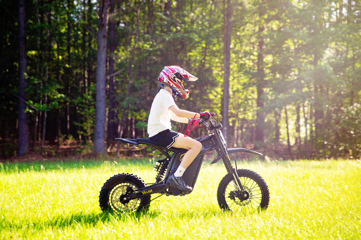 A kid riding a Heybike V1 on the grass